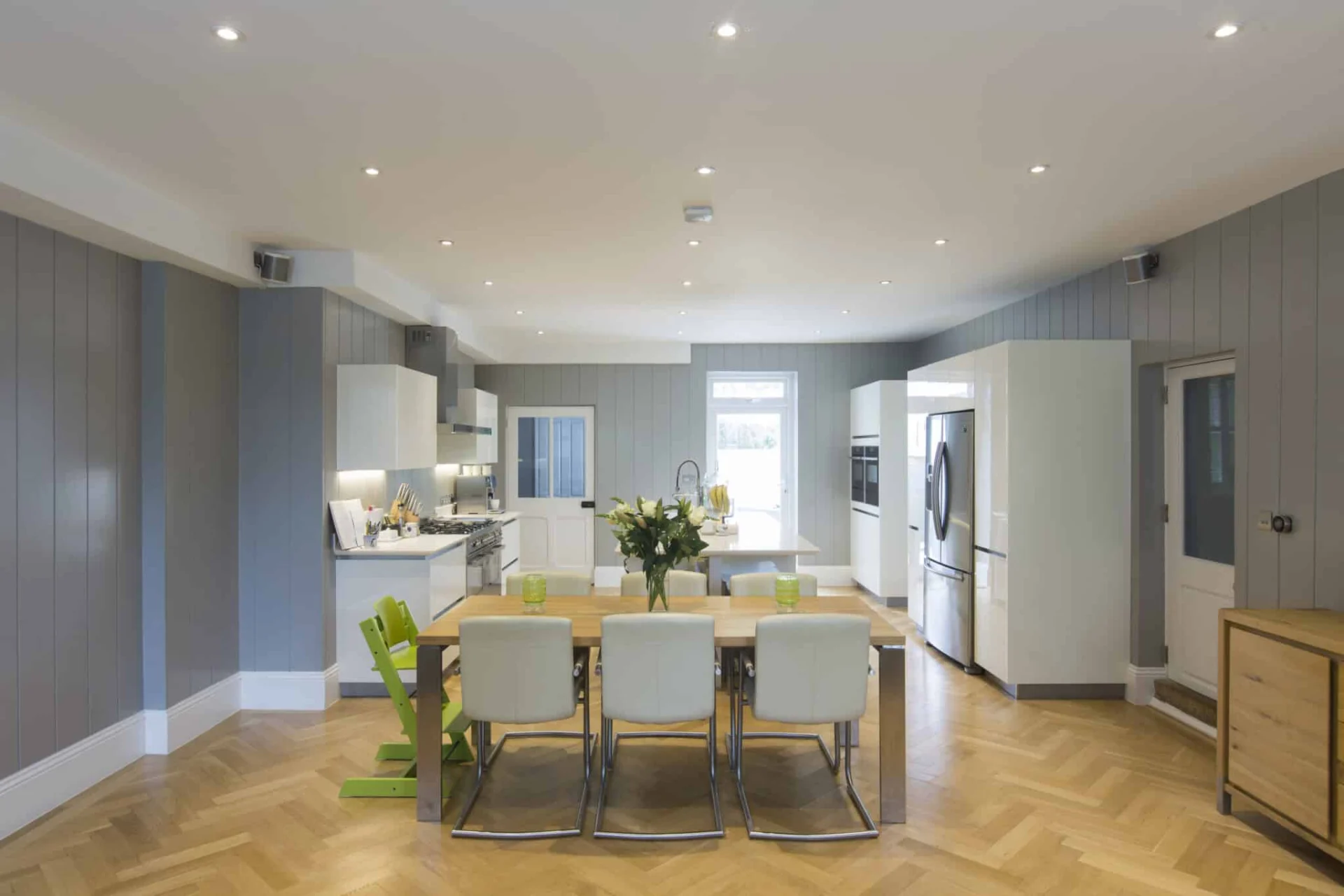 Modern kitchen with dining area and stainless steel appliances.
