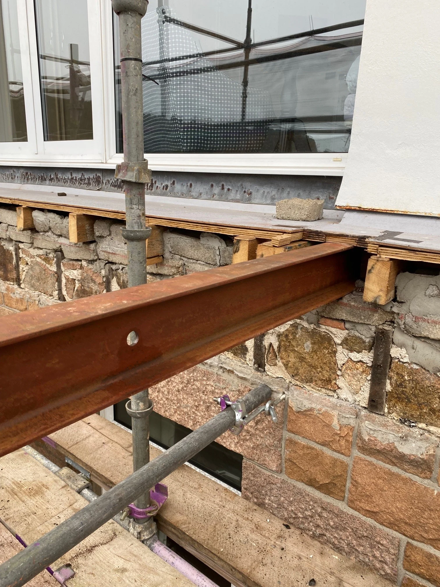 Building construction with steel beam and scaffolding