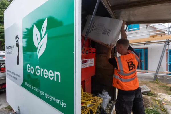 Worker loading bag in Go Green truck