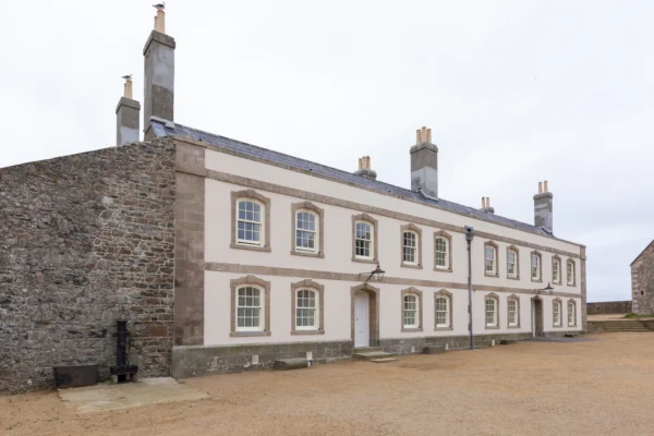 Historic stone building with chimneys and windows.