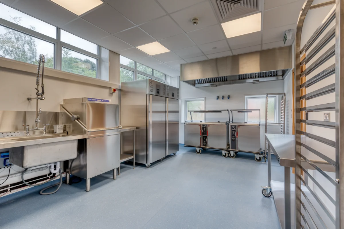 Modern commercial kitchen with stainless steel appliances.