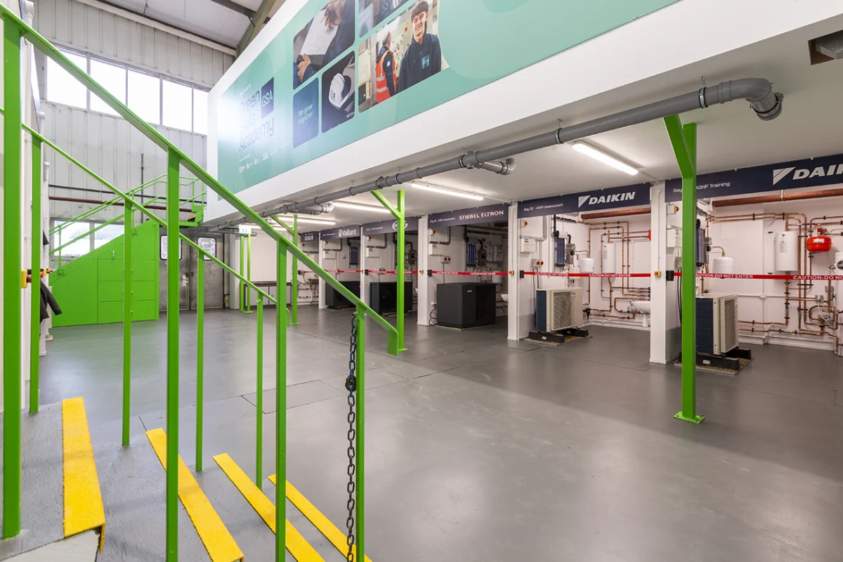 Heat pump training workshop with equipment and green stair railings