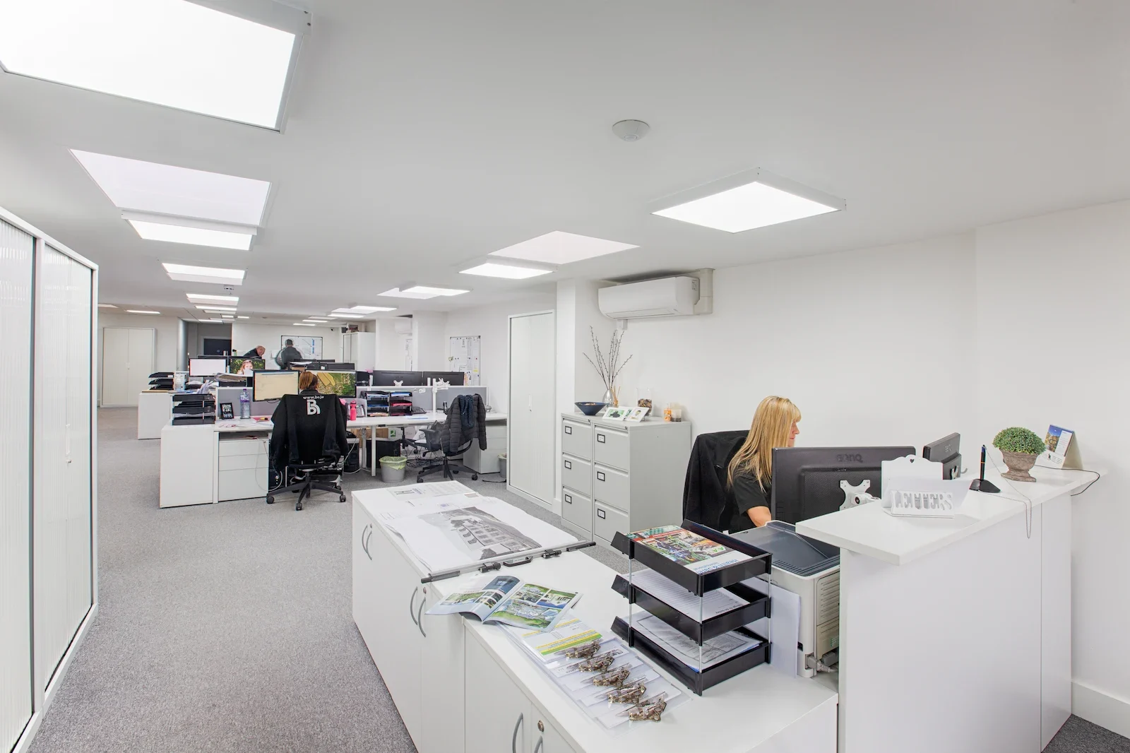 Modern open-plan office with desks and computers.