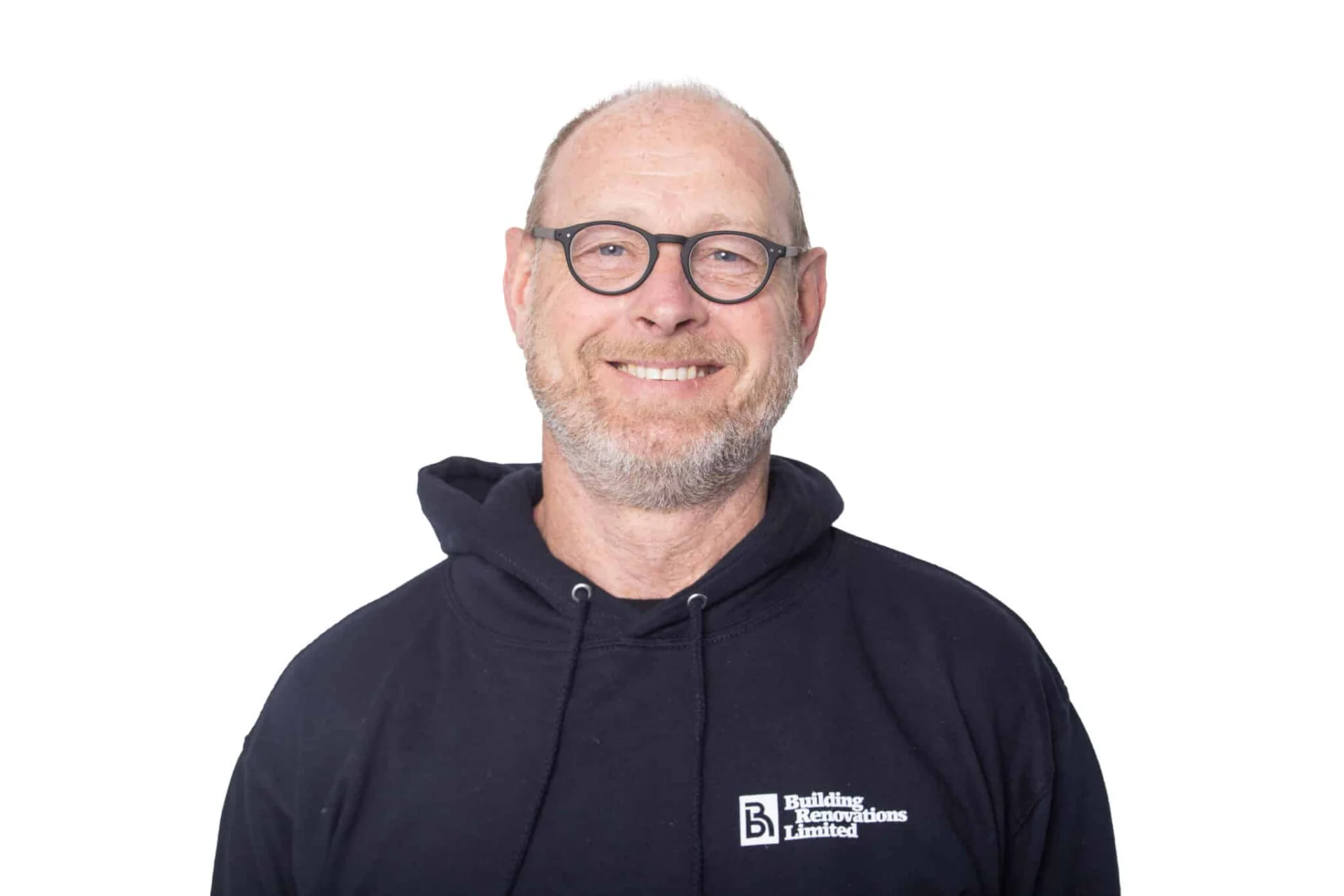 Man wearing glasses and hoodie, smiling.