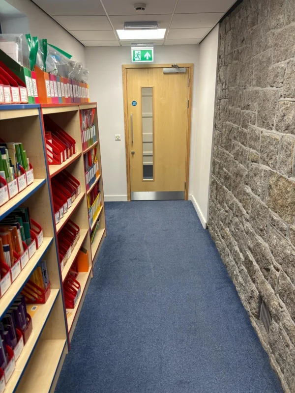 Office corridor with shelves and exit door.